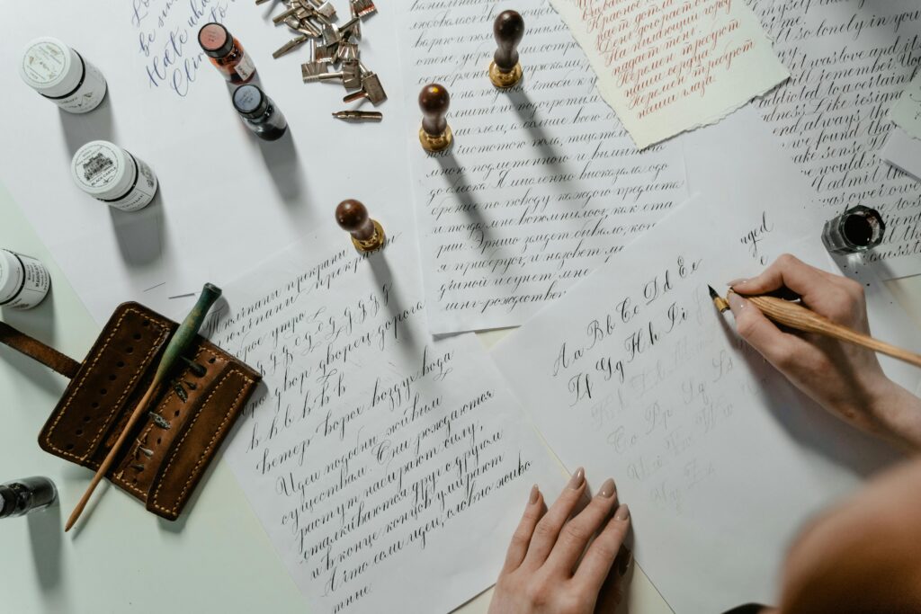 A flat lay of elegant calligraphy practice with tools and inks, showcasing handwritten art.